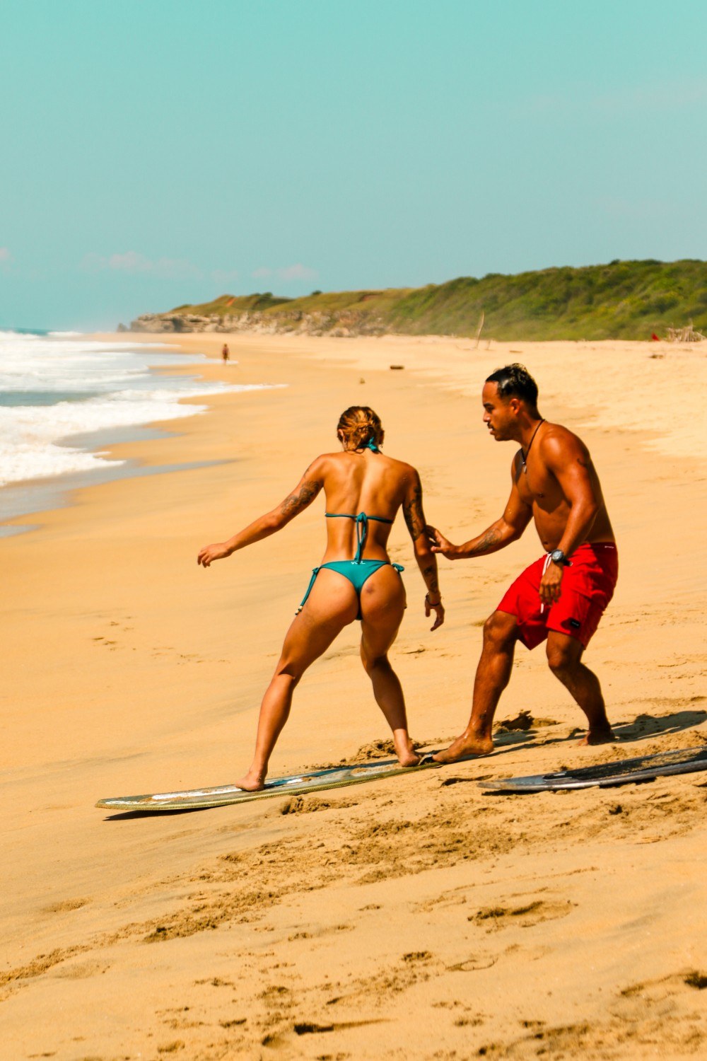Instructor guiando una clase privada de skimboard en la playa.