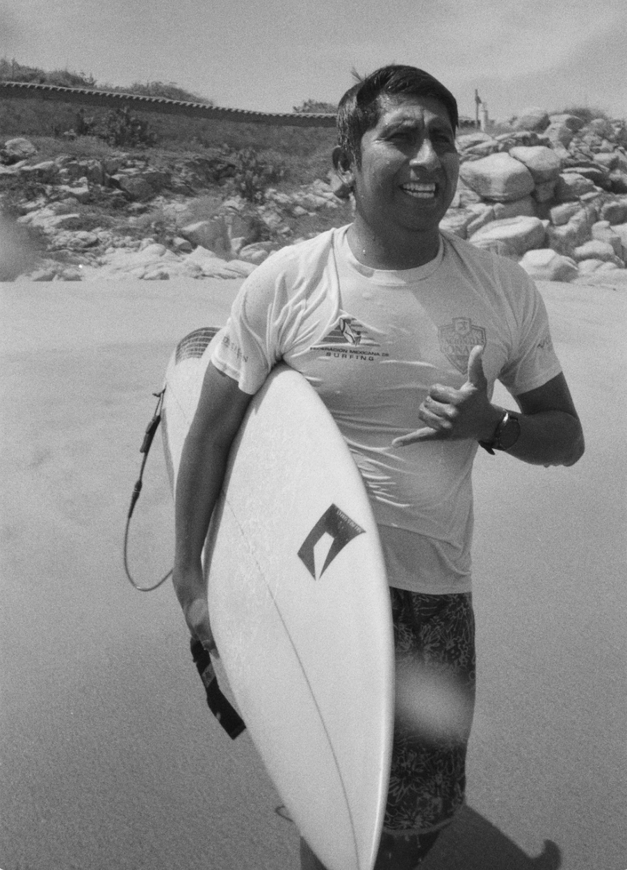 Instructor de Paraíso de Olas en la playa con tabla de surf