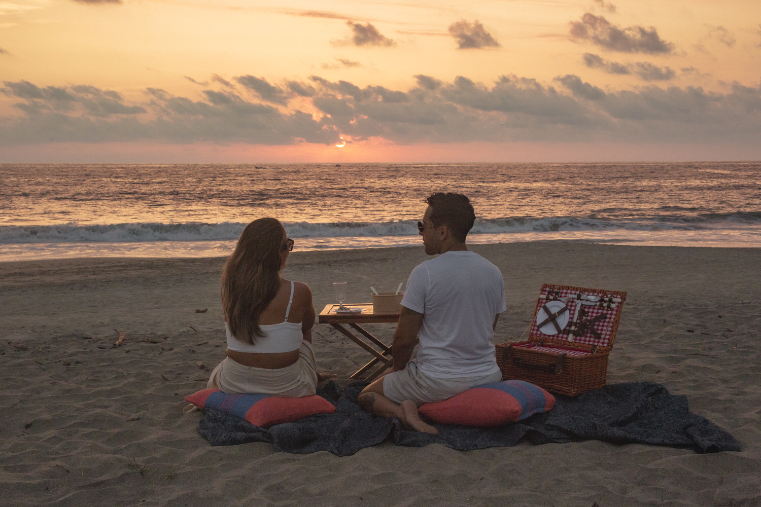 Pareja disfrutando picnic frente al mar